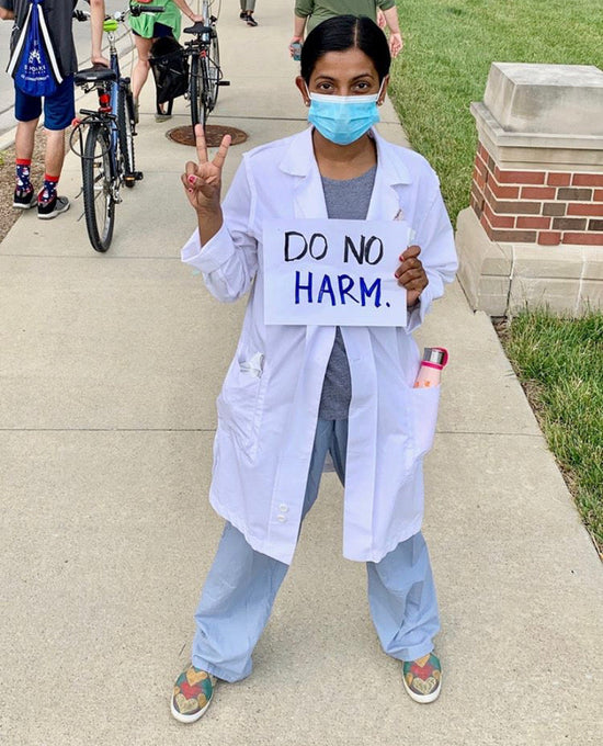 Dr Manasa Mantravadi holding sign that says 