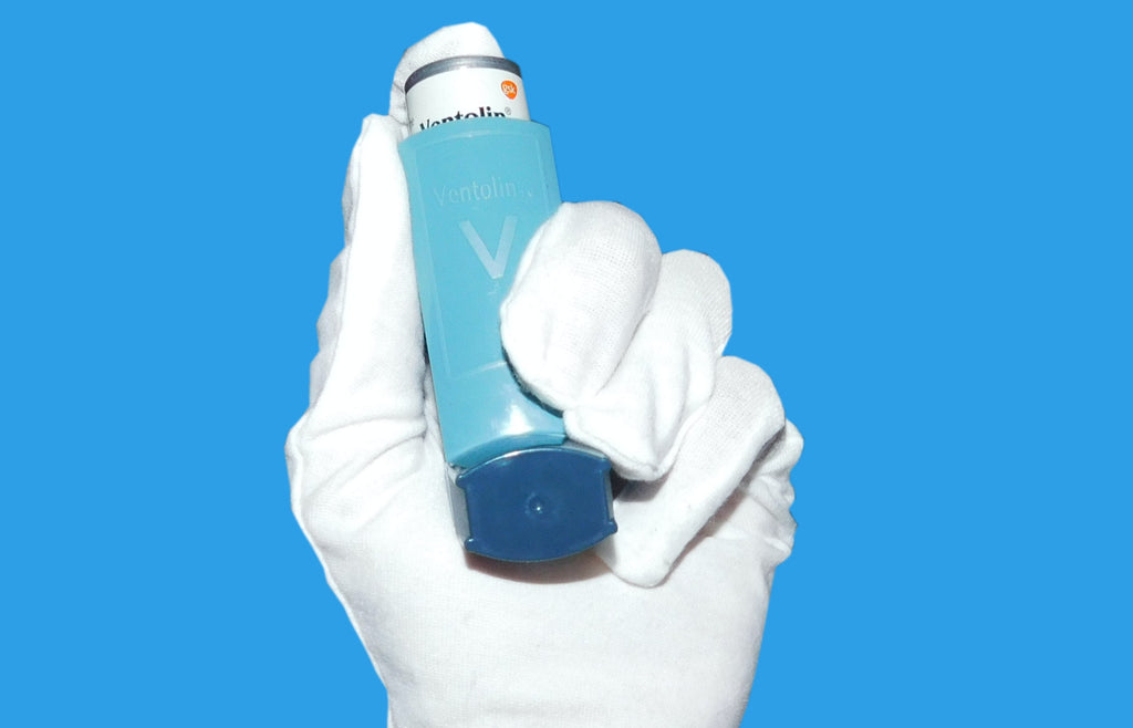 hand with doctor glove holding medication for asthma