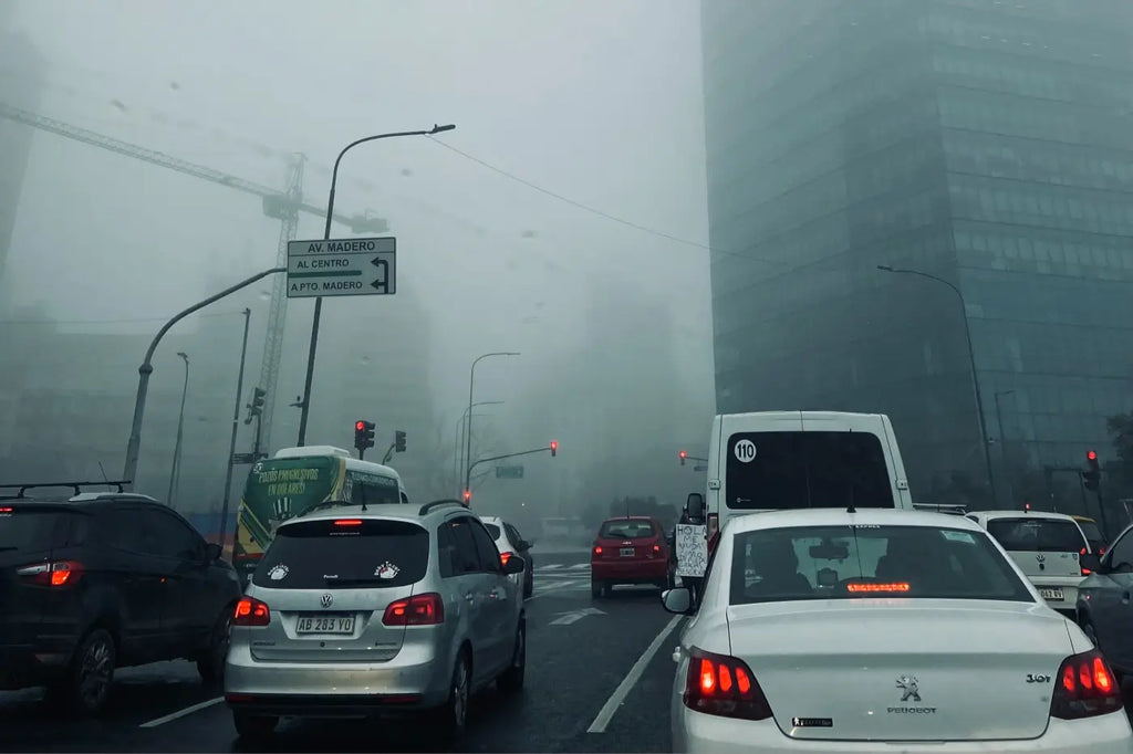 voitures bloquées dans le trafic avec du brouillard qui dégagent de la pollution