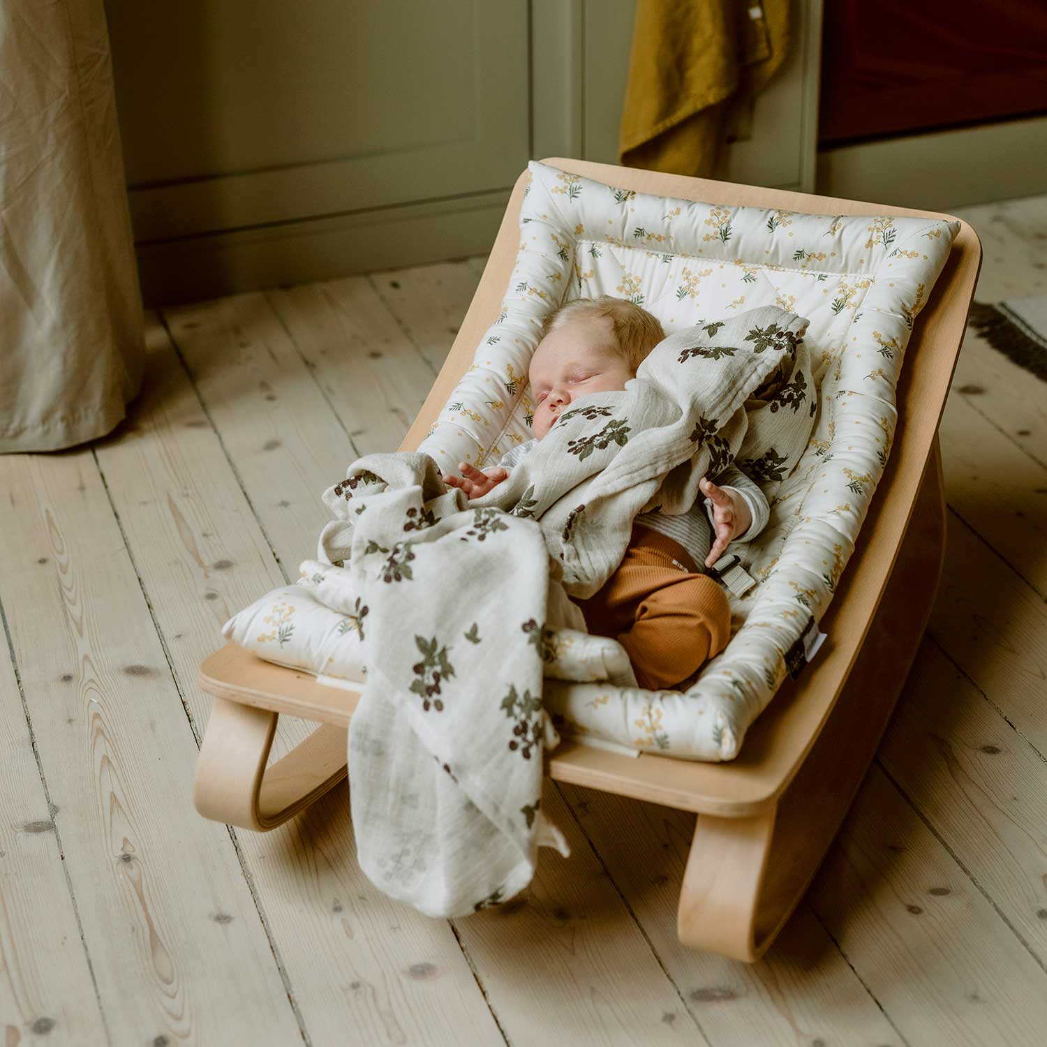 Newborn baby in the Charlie Crane Levo Rocker in Mimosa, with a Garbo&Friends muslin