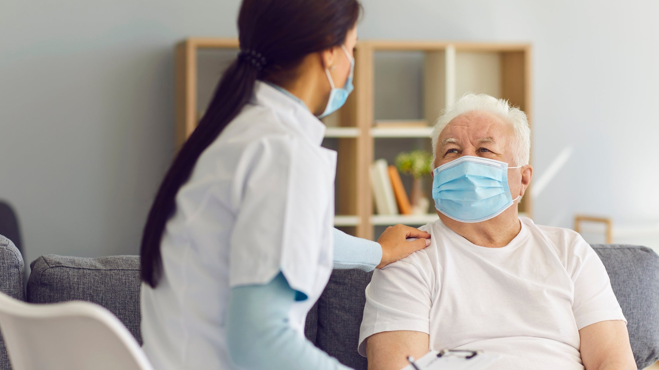 elderly man sitting while talking to a doctor