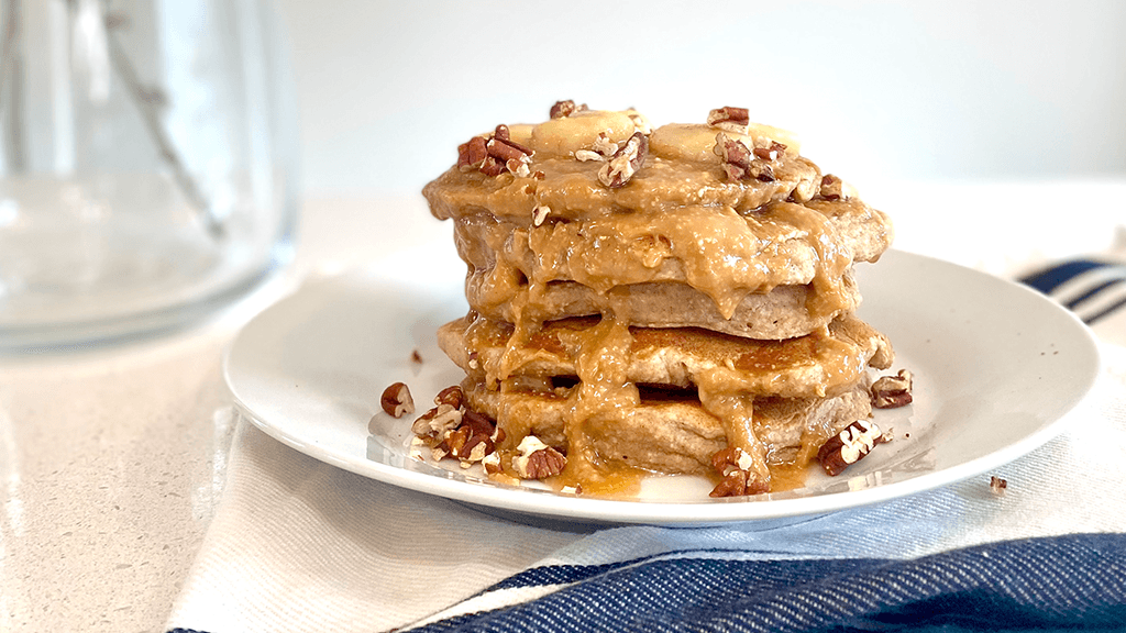 Stack of protein banana pancakes with peanut butter syrup.