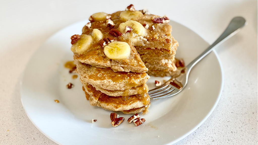 Oat pancakes with peanut caramel drizzle and banana slices.