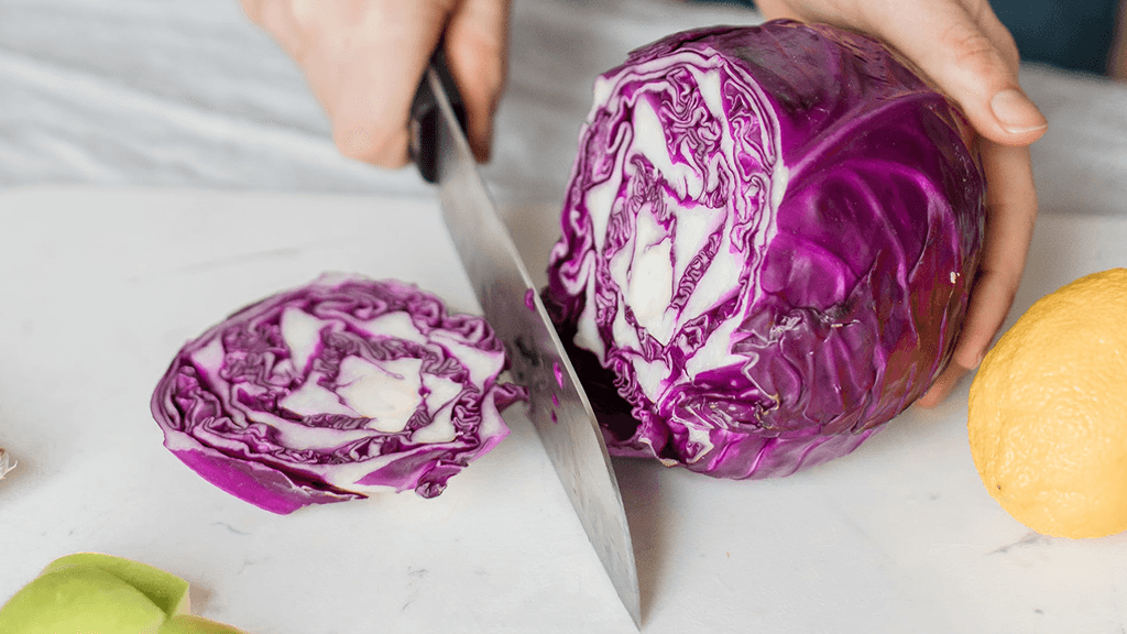 Chopping-full-purple-cabbage-on-cutting-board