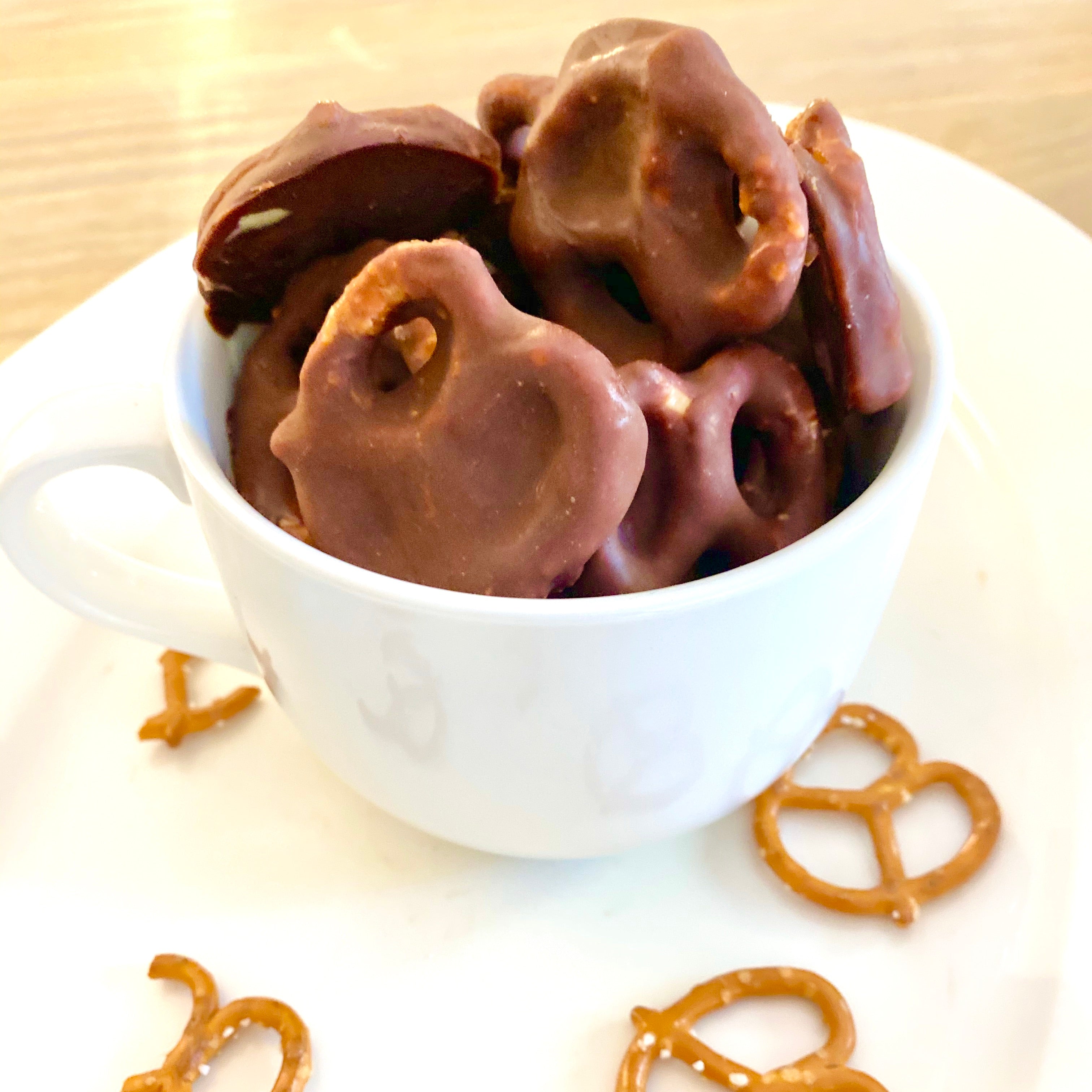 Pretzels covered in Natural Peanut Butter and chocolate, in a mug.