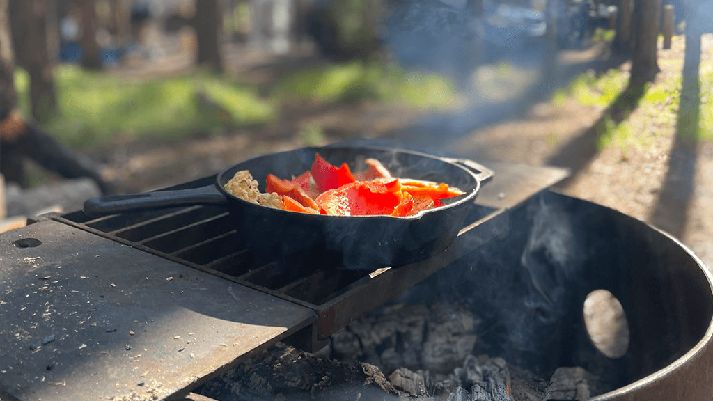 Veggies-Cooking-Over-Fire-On-Cast-Iron-Pan