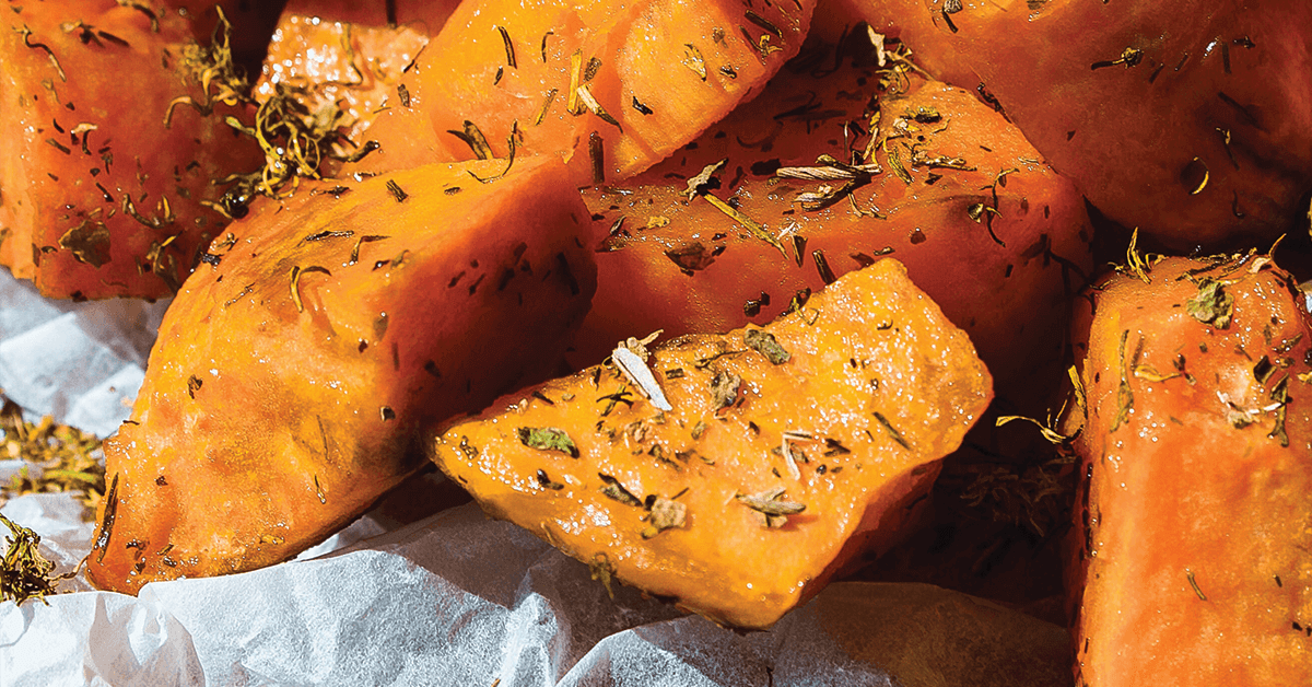 Chopped cooked sweet potatoes sprinkled with herbs
