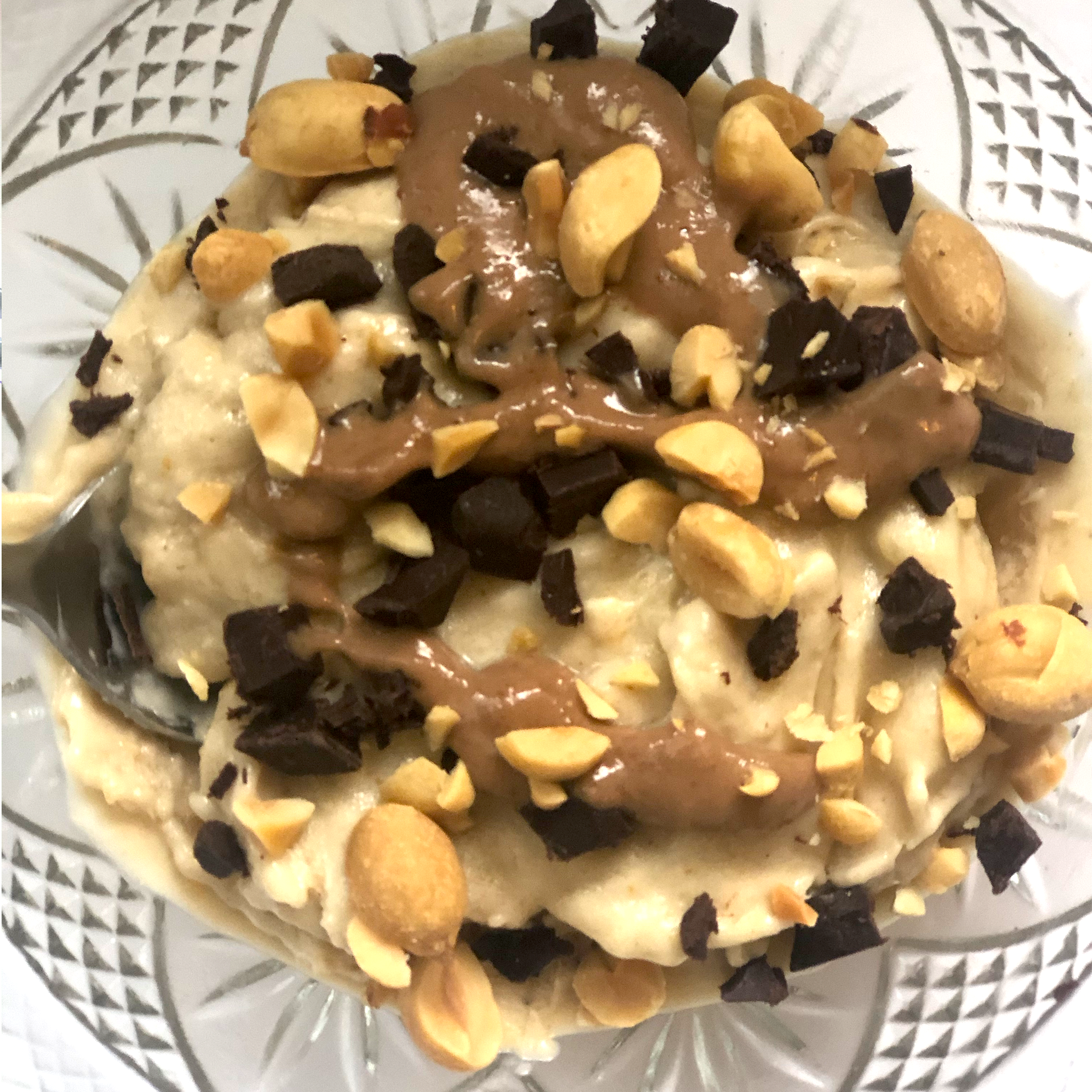 A bowl of Banana Natural Peanut Butter Nice Cream topped with chocolate natural peanut butter, peanuts and chocolate chips!