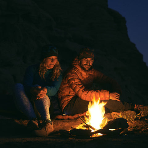 a man and woman enjoying the bonefire in the mountains