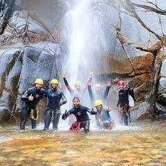 seven hiking friends cooling off under a waterfall