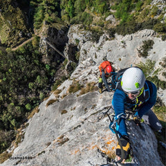 a person is hiking on the rock with the FERRATA set