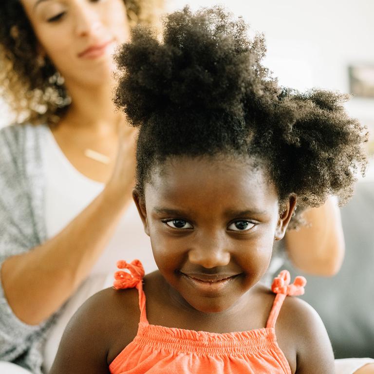 Mother Fixing Her Biracial Curly Hair Daughter