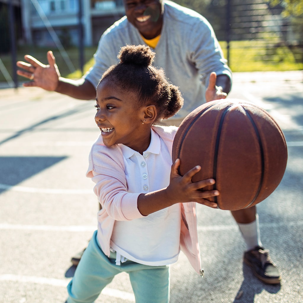 Girl Playing Basketball with Dad