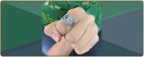 Bague viking au doigt dune femme avec un fond vert et gris