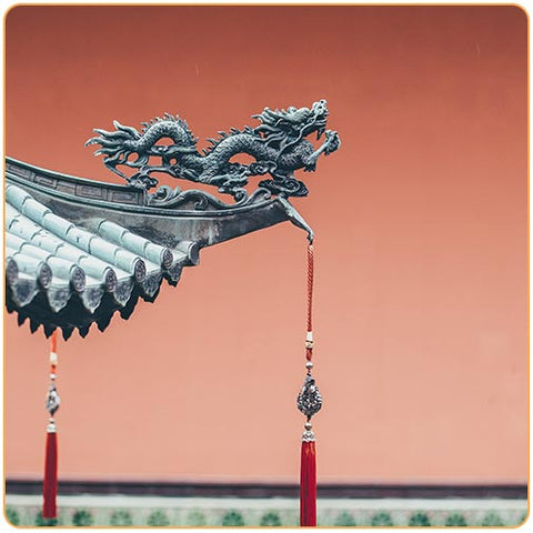 Dragon chinois sur la toiture d'un temple chinois avec ciel rouge en fond Kaosix