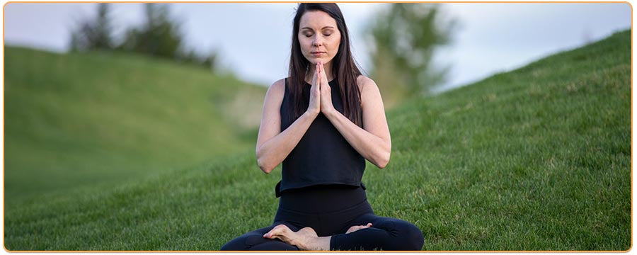 Femme en position du lotus yoga sur de l herbe dans la montagne Kaosix