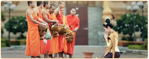 Jeunes moines bouddhistes thaïlandais recevant une offrande de la part d'une jeune thaïlandaise Kaosix