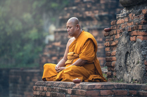 Moine bouddhiste en méditation sur les ruines d'un temple Kaosix