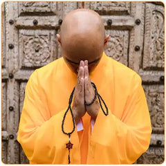 Moine bouddhiste en tunic orange qui prie et qui tient un chapelet mala dans les mains Kaosix