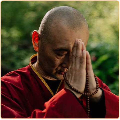 Moine tibétain en prière les deux mains jointes et la tête inclinée Kaosix