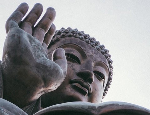 Tete de statue geante de bouddha avec sa main devant le visage Kaosix
