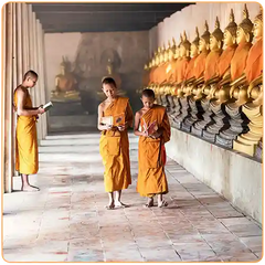 Trois jeune moines bouddhistes tibétains étudiant des livres à côté de statues de Bouddha kaosix