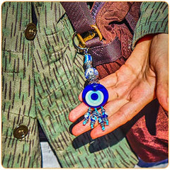 Une personne tenant une grosse amulette du nazar boncuk dans sa main Kaosix