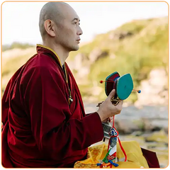 moine tibétain en extérieur tenant un instrument musical dnas ses mains Kaosix