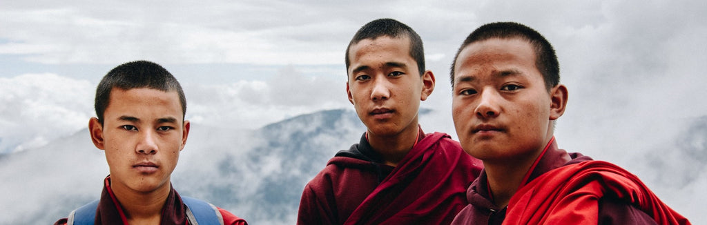 portrait de 3 jeunes moines bouddhistes avec la montagne en fond kaosix