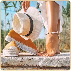une jambe de femme avec un bracelet de cheville coquillage un chapeau de paille et des chaussures de plage Kaosix