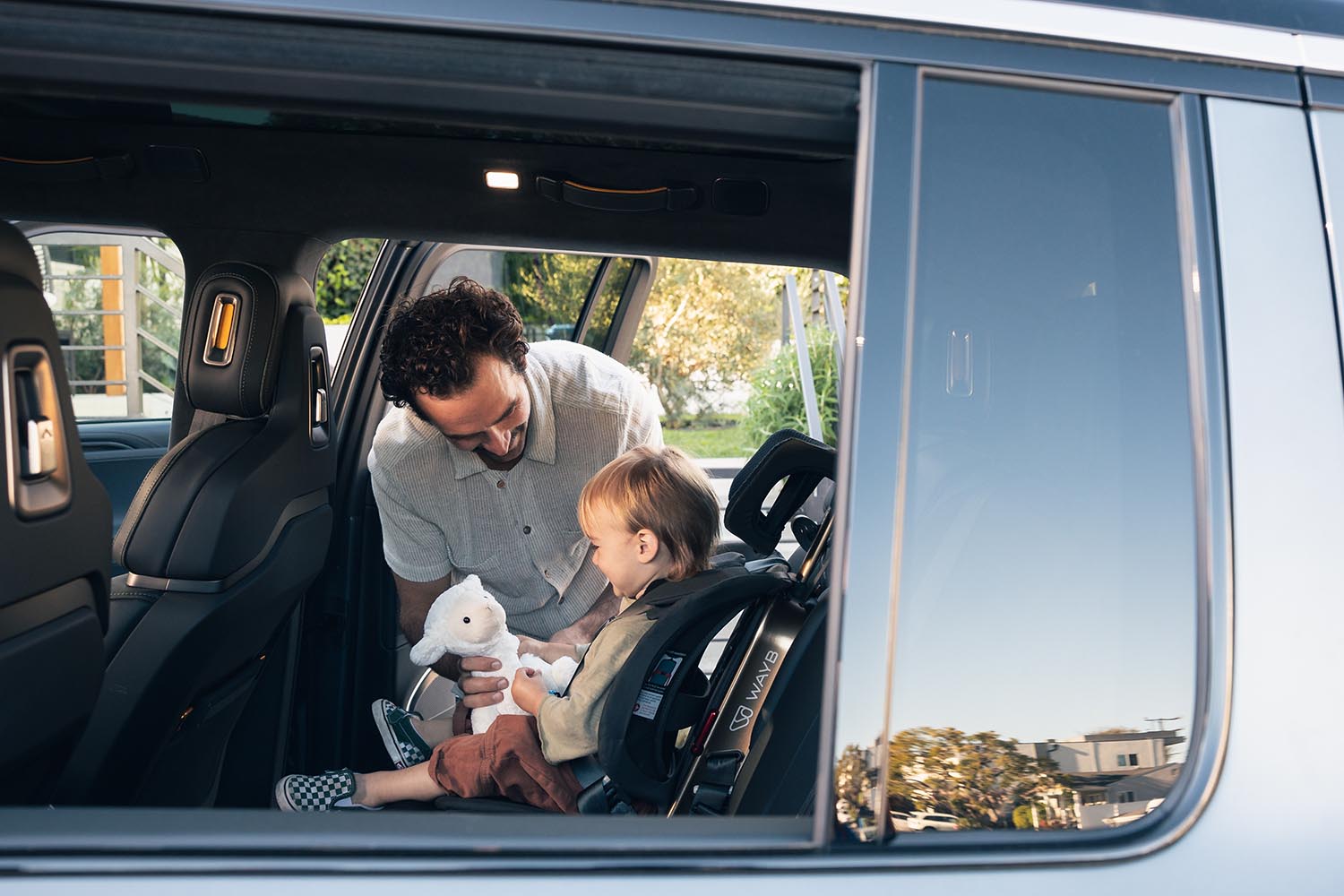 Parent buckles the baby up in the car seat