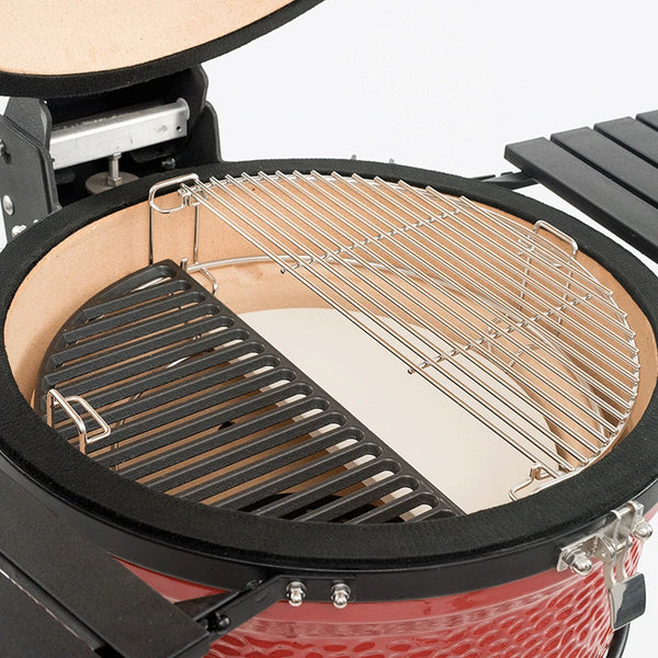 The Divide & Conquer system installed in a Kamado Joe grill. The lower tier holds a cast iron half-moon cooking grate. The upper tier holds a stainless steel half-moon cooking grate over a half-moon heat deflector.