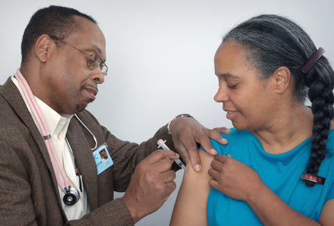 the image shows a doctor giving someone the flu jab