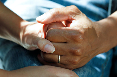 Two hands holding one another in a caring position