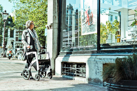 the image shows a woman window shopping with her rollz rollator