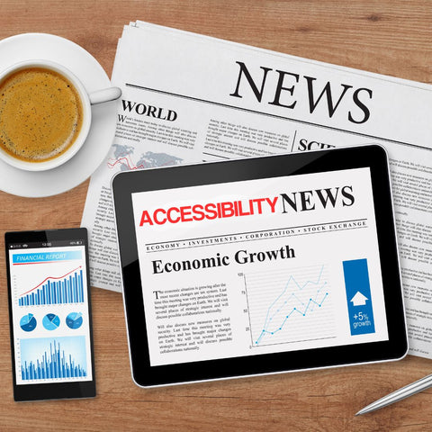 An image of a news site on an ipad, called Accessibility News, on top of a Newspaper, next to a phone with graphs on it, and a cup of coffee