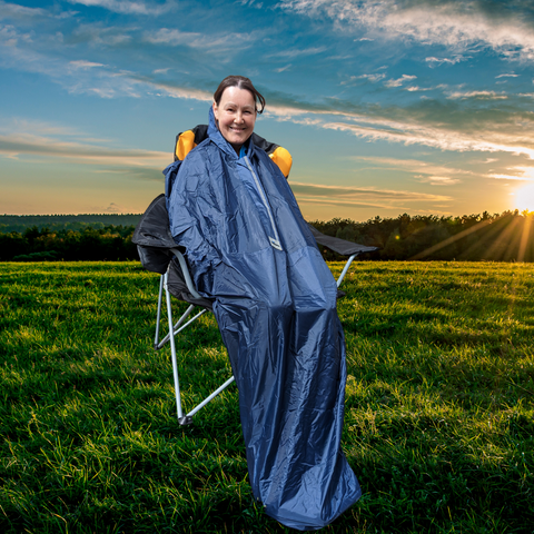 Ability Superstore Staff Member Carol sat in a deckchair, wearing the Simplantex Wheely Mac, with the sun setting on a festival field behind her.