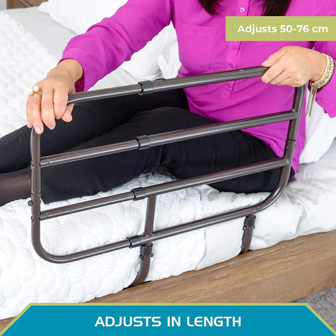 A picture of the Extend-A-rail rail being used. The legs of the item are securely positioned under the mattress and a woman is holding onto the rail; she is lying on the bed