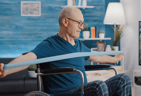 An image of a man in a wheelchair using a stretch band to exercise with