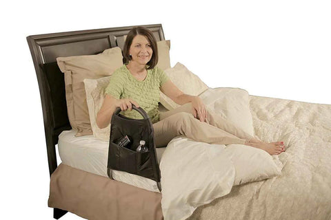 A woman is lying in bed. The Mighty Rail is positioned with its legs under the mattress