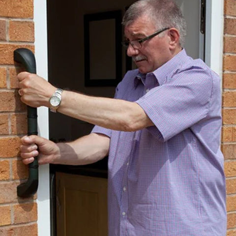 A man standing outside his front door to his house – he is holding onto the Prima Outdoor Grab Rails