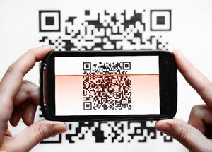 the image shows a mobile phone scanning a QR code