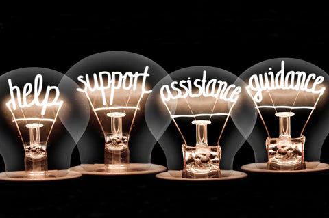 Four lightbulbs where the filaments have been replaced by the following words – help, support, assistance and guidance