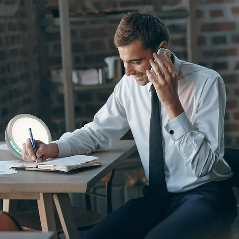 Man working at desk with SAD therapy light by Lifemax