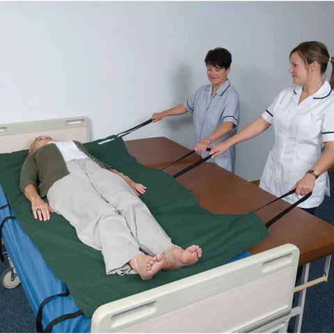 Two nurses using a glide sheet to transfer a patient
