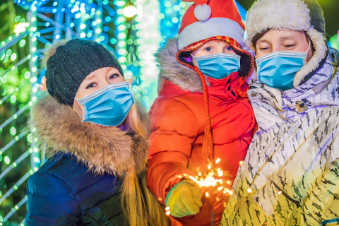 the image shows a family at an outdoor Christams event wearing face masks