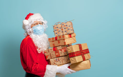 the image shows Santa Clause delivering presents and wearing a face mask