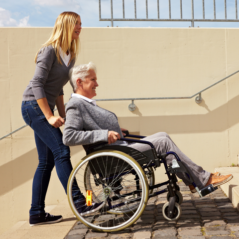 Woman pushing elderly woman on wheelchair