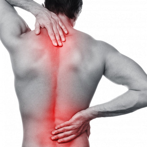 A black and white image of a man with back pain. The painful areas are highlighted in red and he's holding his back to try and get some relief.