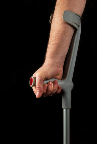 A close up of an arm and a hand using a forearm crutch